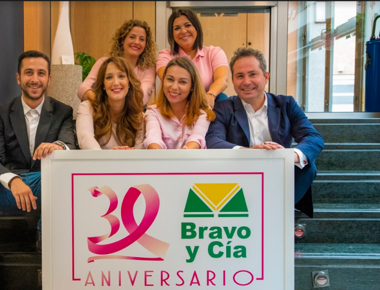 Equipo de Seguros Bravo con un cartel del 30 aniversario